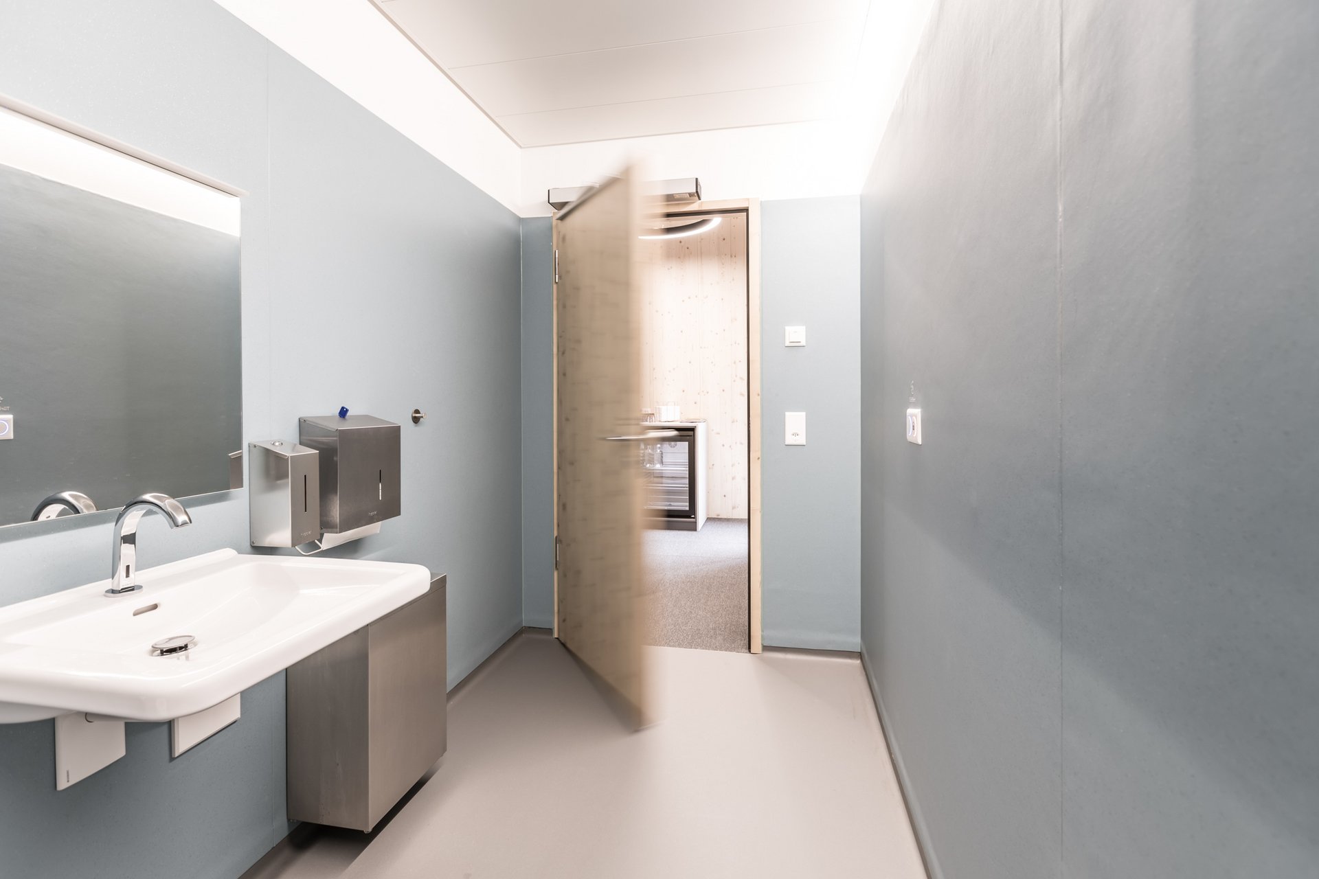 Toilette des Swiss Bike Parks in Oberried mit einer automatischen Drehflügeltür