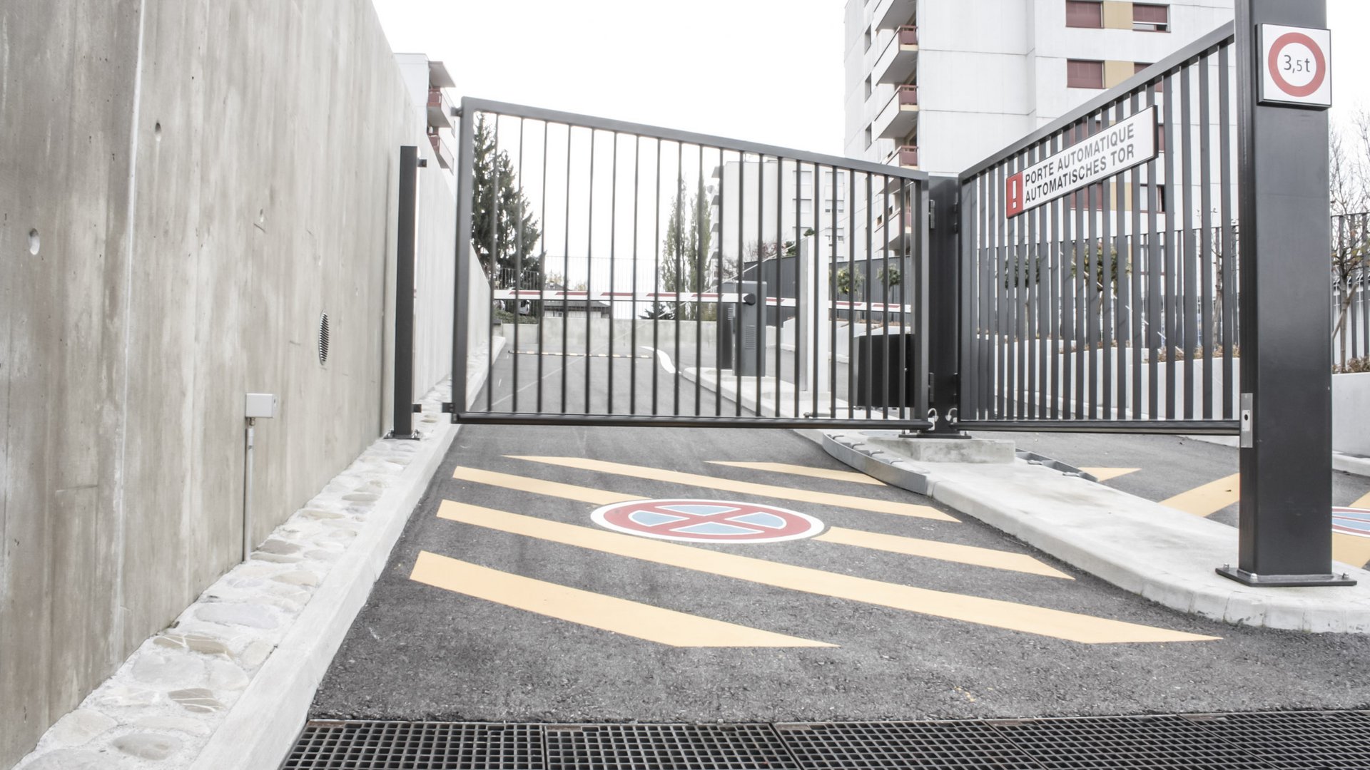 Parkplatzeinfahrt zum CFK-Modelleisenbahnmuseum in Granges-Paccot mit automatischen Torantrieben